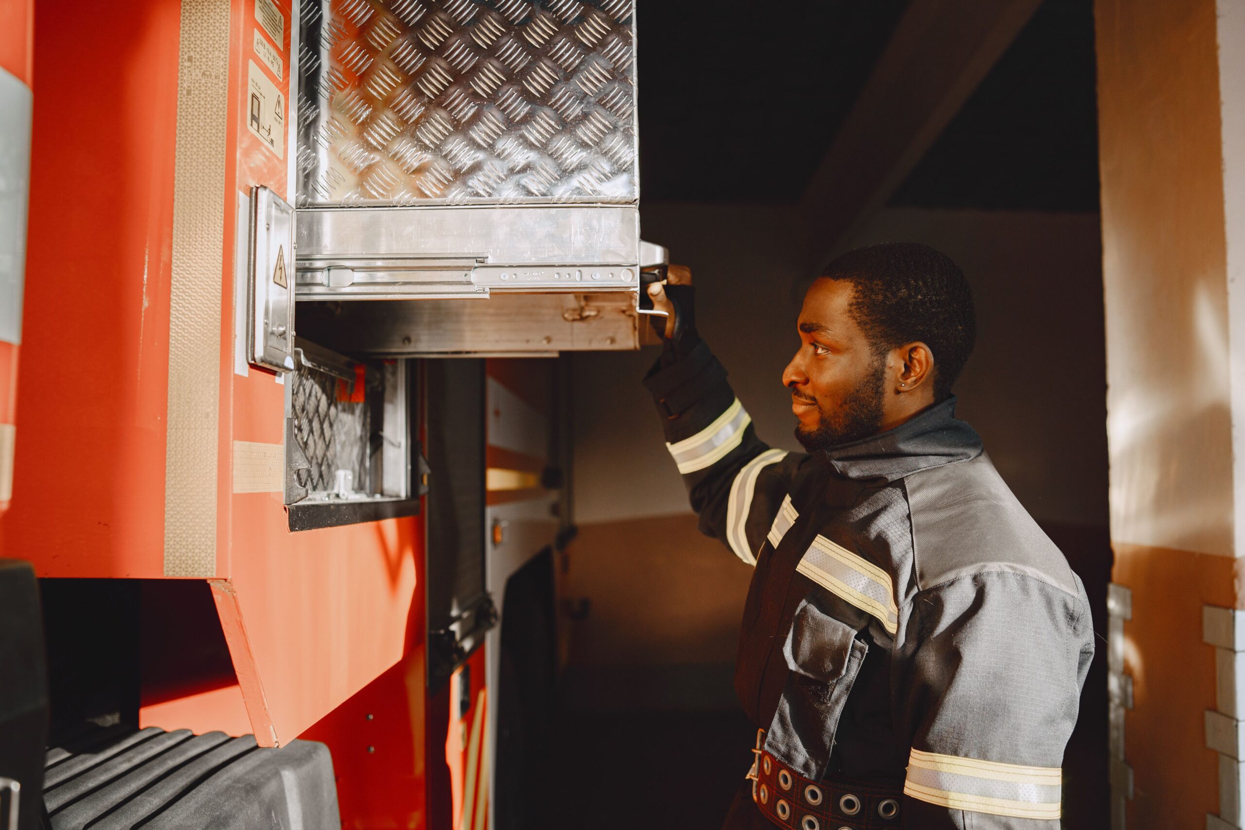 Pompier africain en uniforme pres d'un camion de pompiers